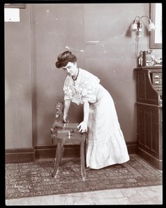 Uma mulher demonstrando uma cadeira especial na Aeolian Co., Nova York, 1906 ou 1907 (impressão de gelatina de prata)